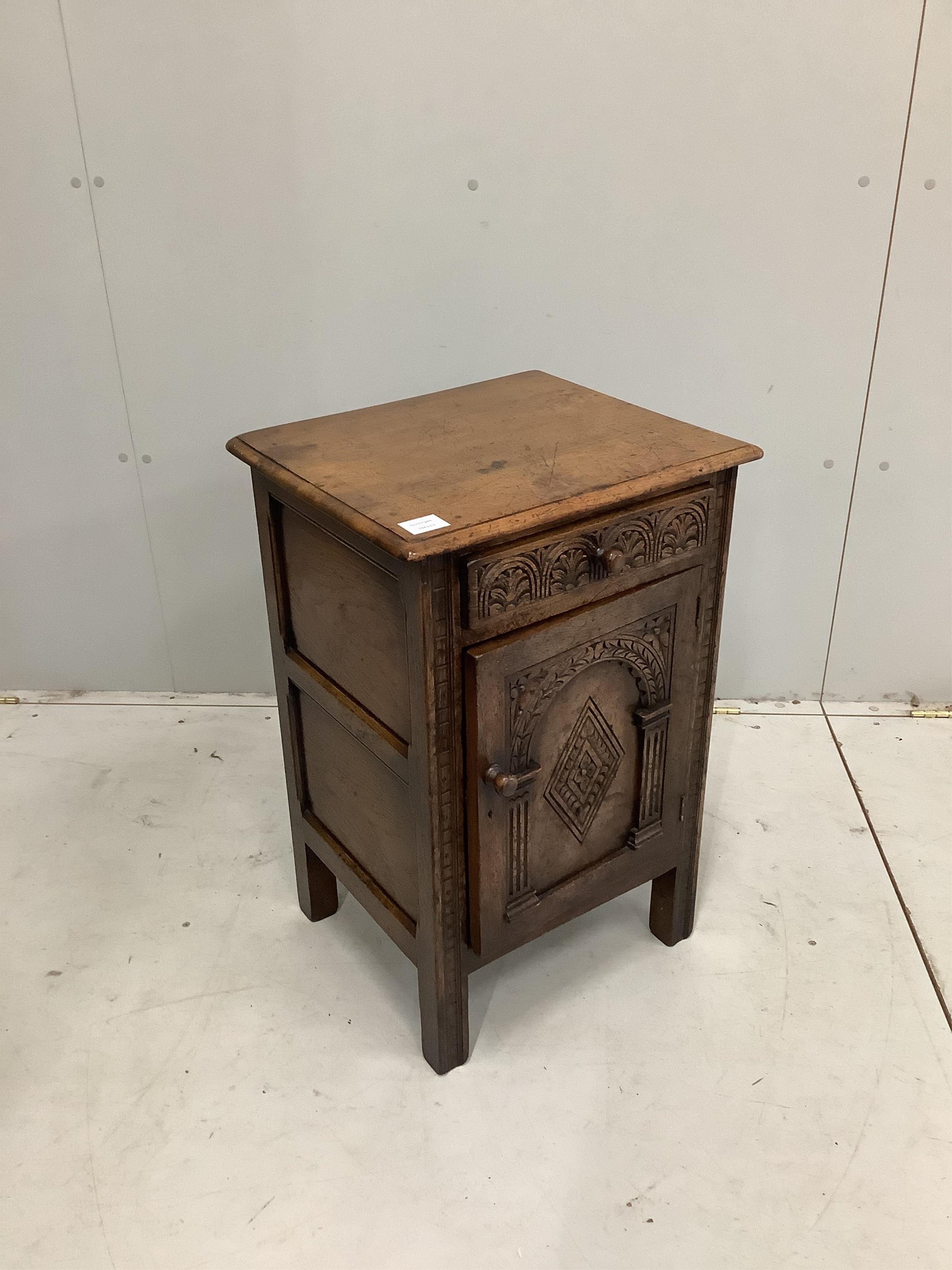 A Tudor style carved oak bedside cupboard, width 47cm, height 71cm. Condition - good